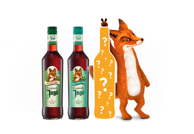 Auf dem Bild sind zwei unterschiedliche Fläminger Jagd Flaschen, sowie ein Fuchs zu sehen, der eine gelbe Flasche mit aufgedruckten Fragezeichen hält